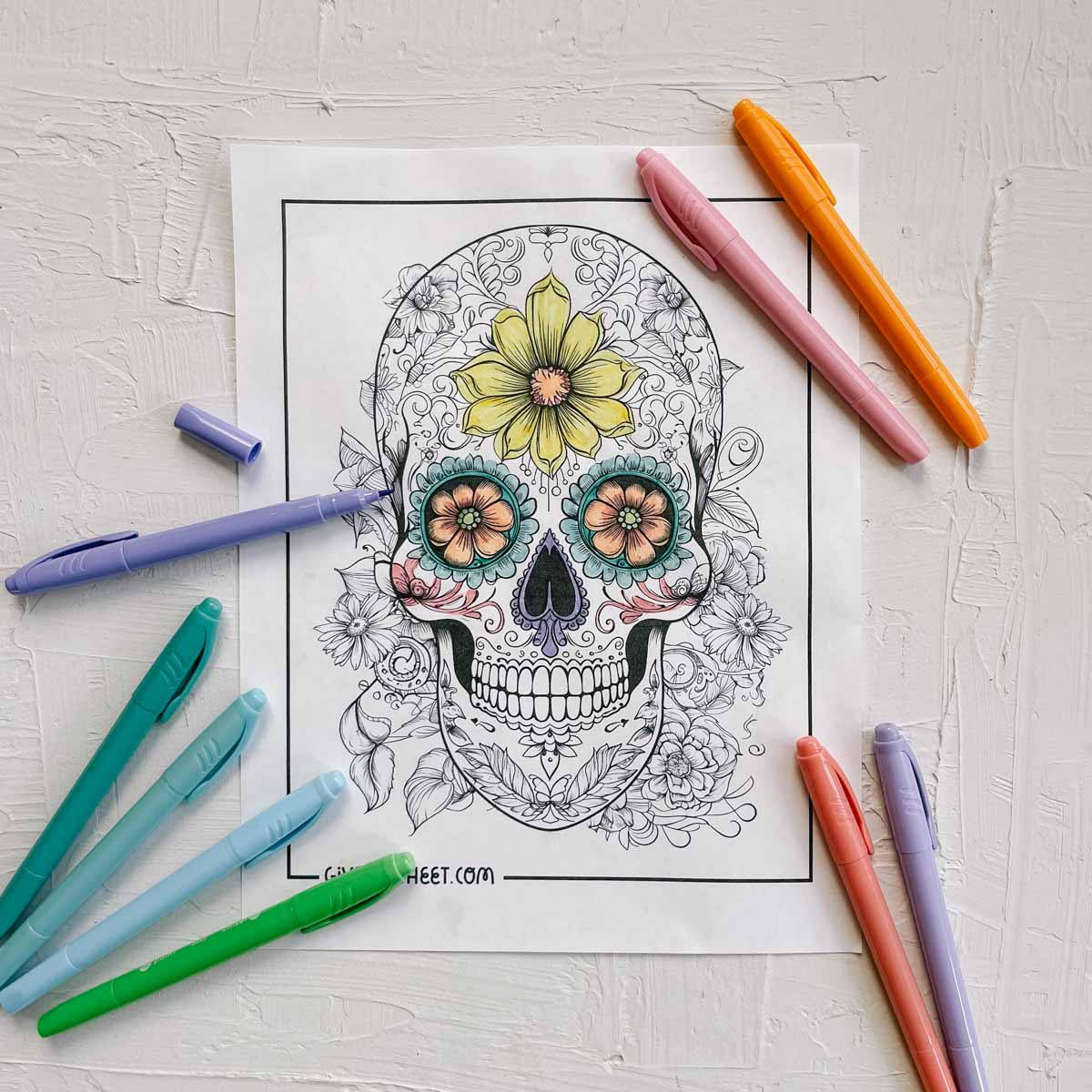 A detailed sugar skull coloring sheet in progress of being colored.